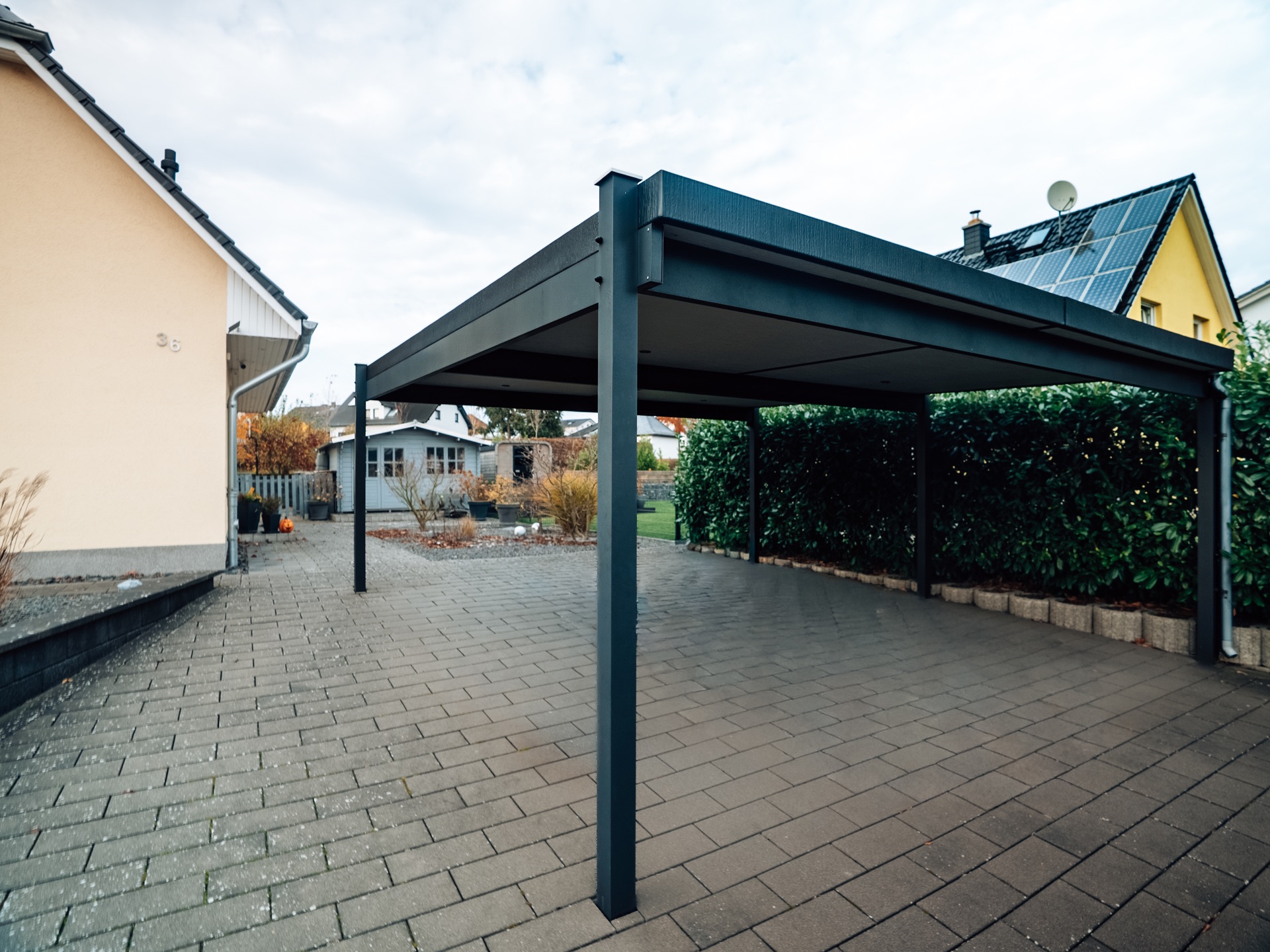 Großzügiger anthrazitfarbener Carport an einem Einfamilienhaus